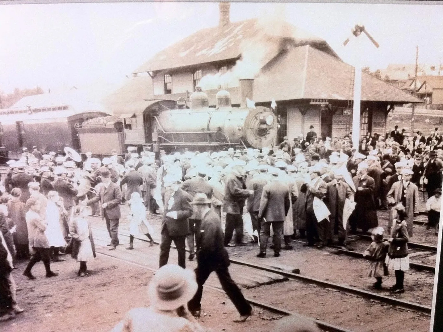 Crowds and a brass band greet a steam train