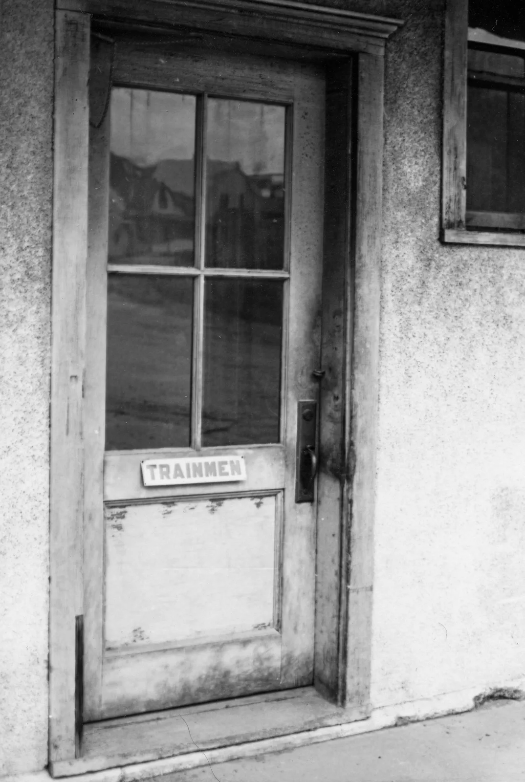 A weathered stucco door marked Trainmen