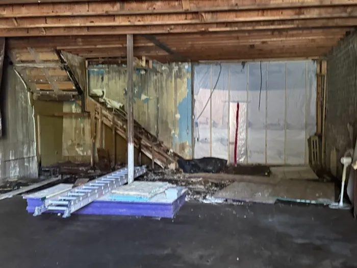 The gutted interior with the old stair, peeling walls and new insulation