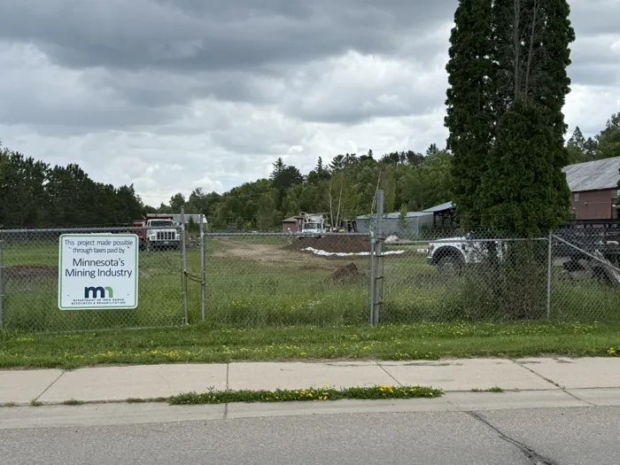 The fenced site at the start of the project, with a sign reading This project made possible through taxes paid by Minnesota’s Mining Industry, from Iron Range Resources & Rehabilitation