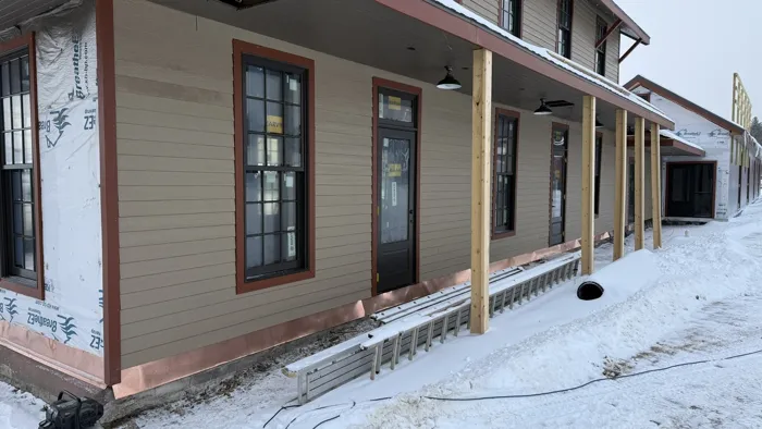 New siding, red trim and Marvin windows along the platform side in the snow