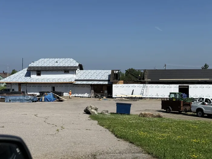 The depot and freight wing wrapped in house wrap, with crews on the roof