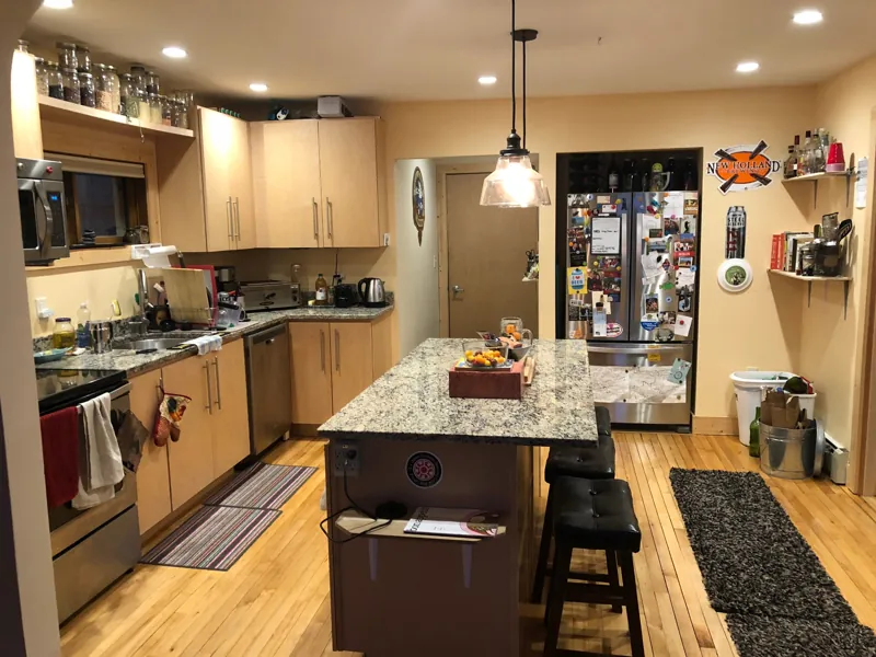 A kitchen with a granite island and stools