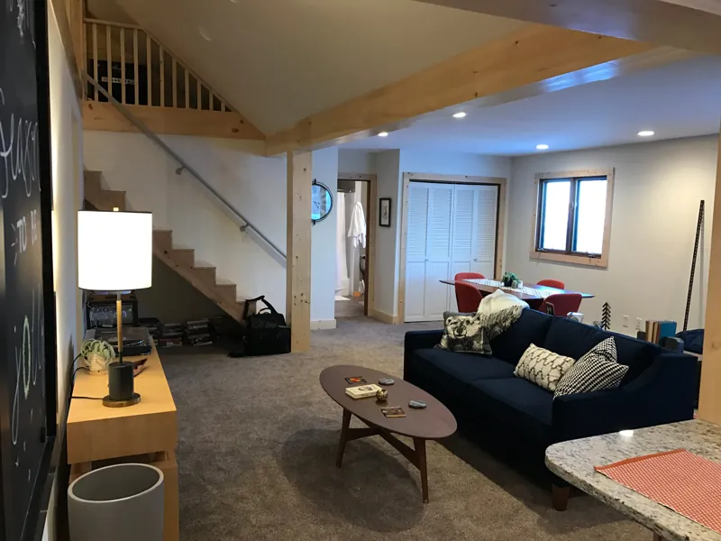 A living room with a navy sofa beneath an open loft