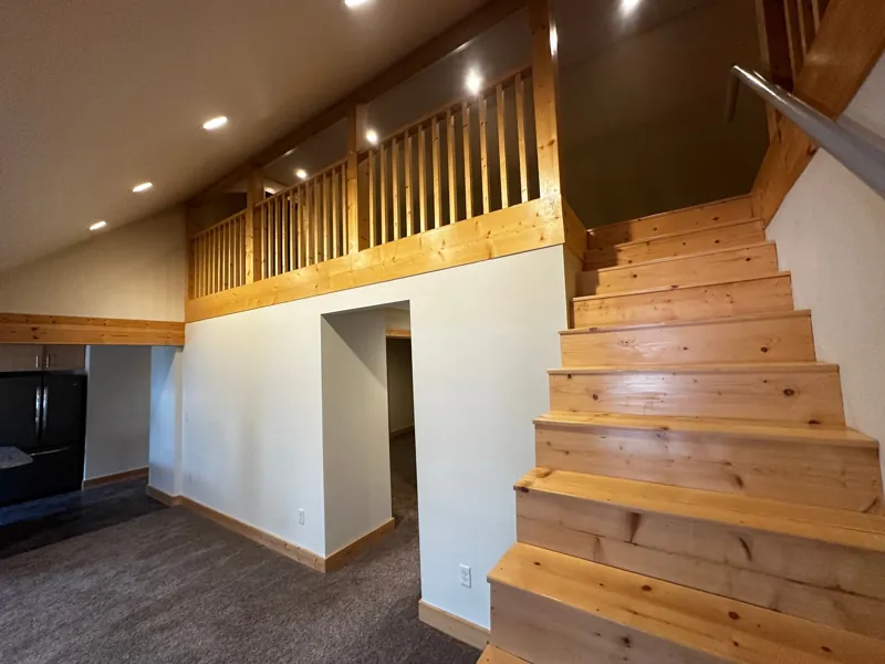 Pine stairs and a loft railing above the living area