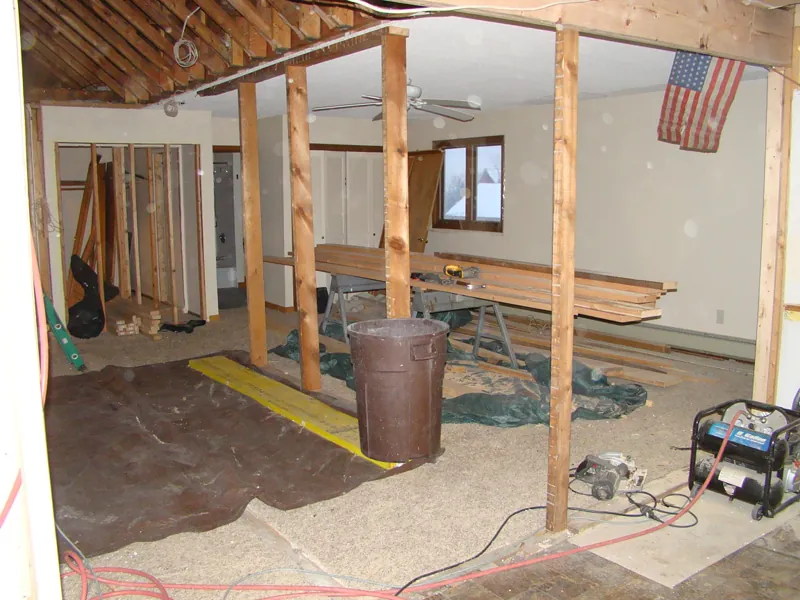 The second floor opened up to the studs, with an American flag on the wall and tools on the floor