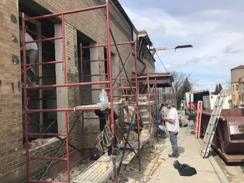 Masons on scaffolding at the brick wall