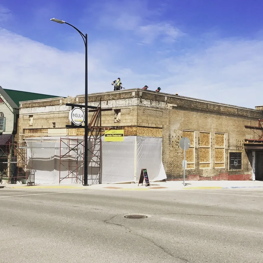 Crew working on the roof above the wrapped storefront