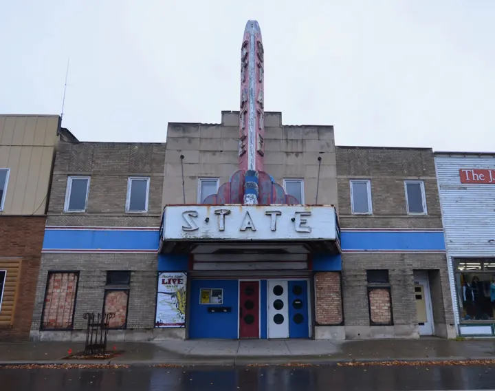 The State Theater front before restoration, with a faded sign and boarded windows