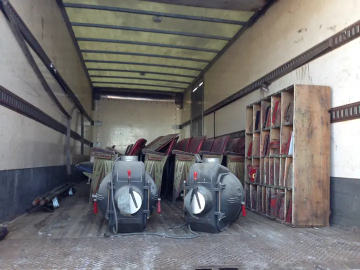A moving truck holding theater seats, two projector lamphouses and a case of red marquee letters