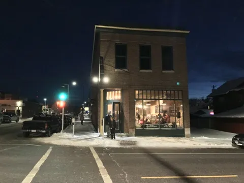 The restored brick building glowing at night on a snowy corner