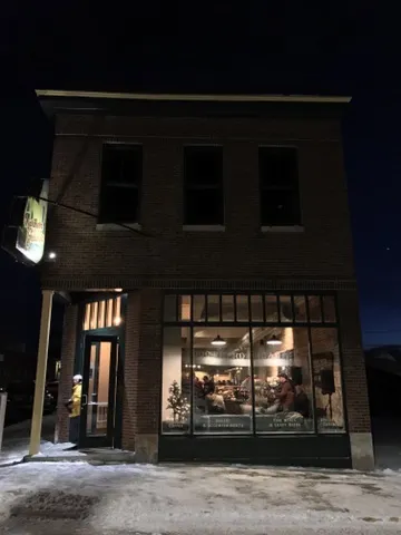 The Northern Grounds storefront glowing at night
