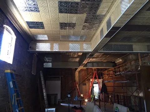 Tin ceiling panels being repaired above scaffolding